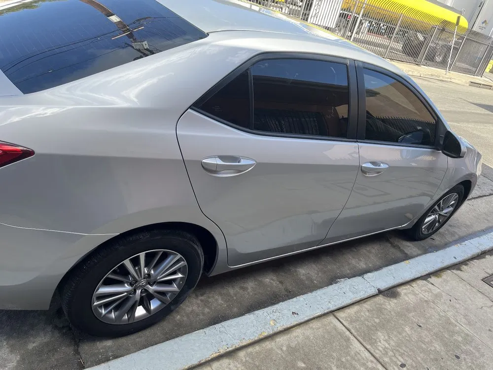Side profile of a silver Toyota Corolla sedan parked at the curb